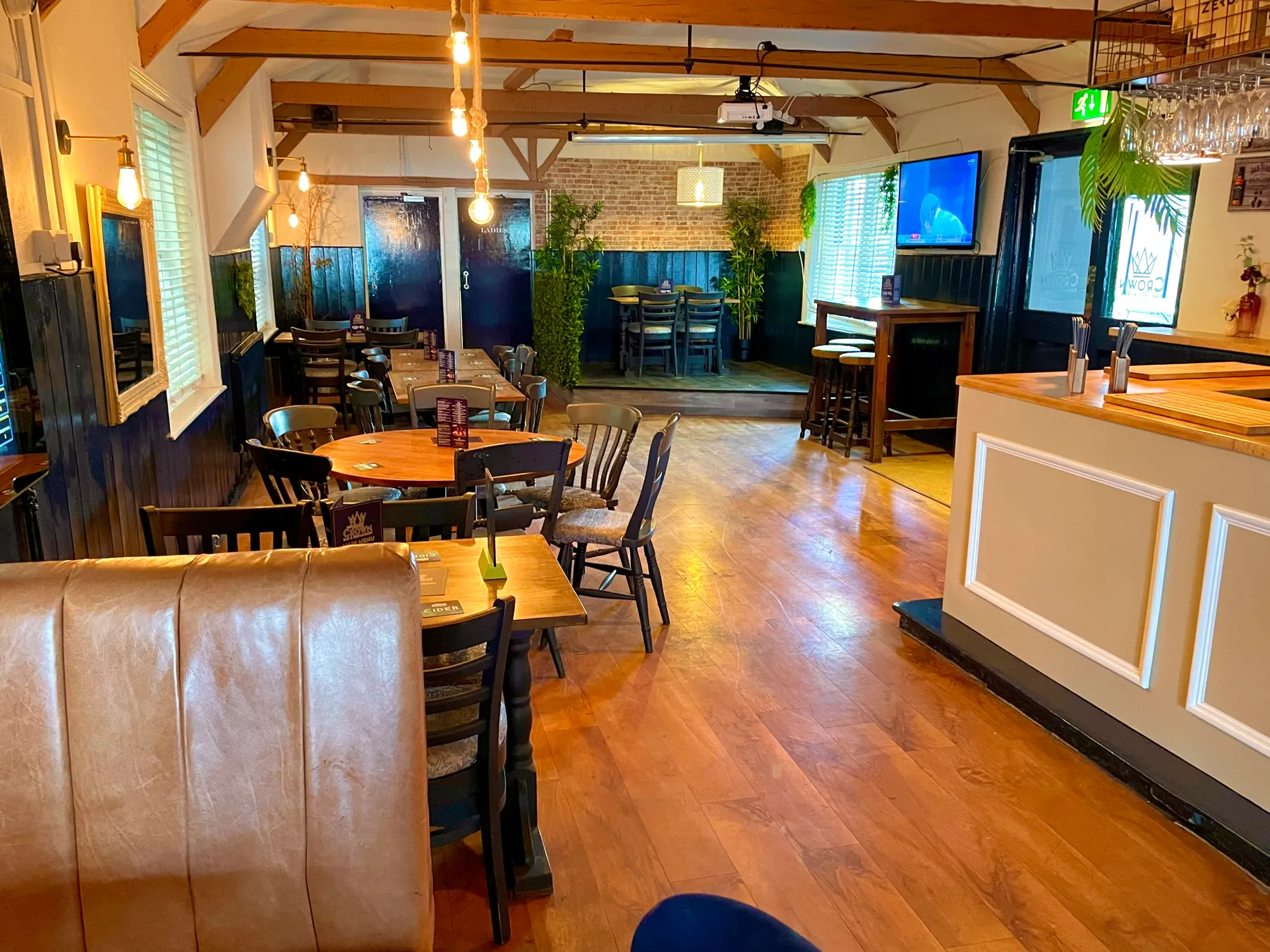 The restaurant at The Crown Inn Selsey, with wooden tables and leather seating