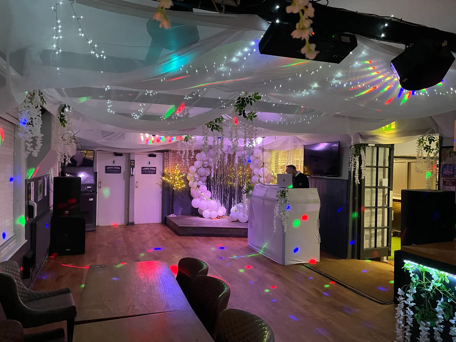 The function space at The Crown Inn Selsey dressed for a party, with drapes, fairy lights and a balloon display