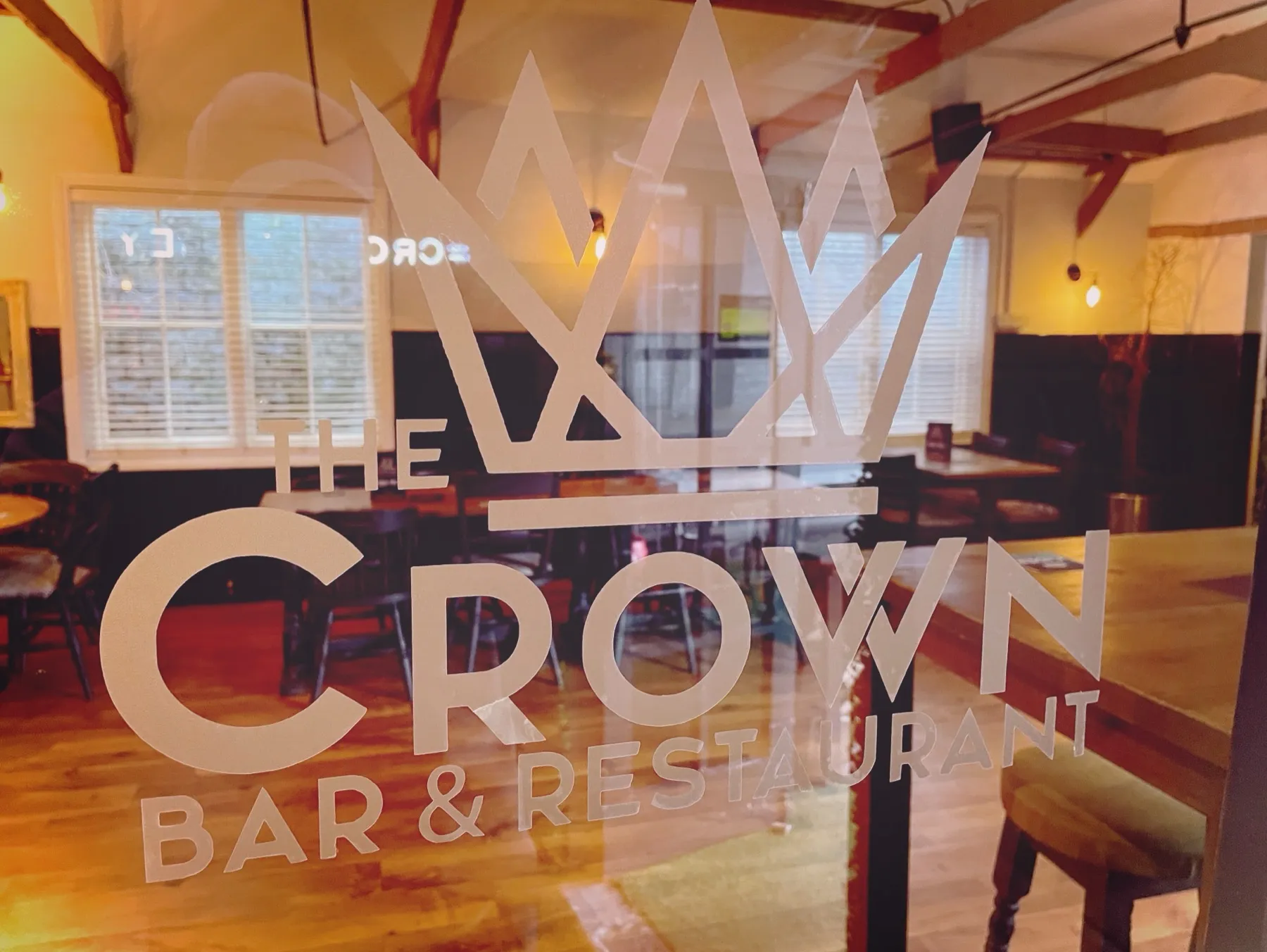 The Crown Bar and Restaurant crown emblem etched on the window, looking into the dining room